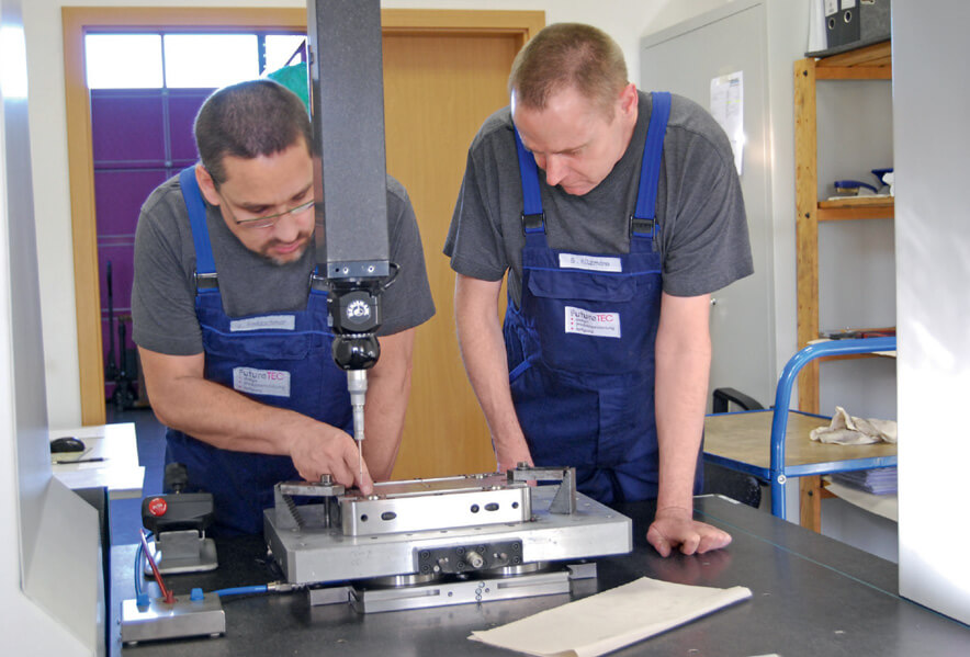 Measurement technician Jürgen Kretzschmar and Sven Kitzmann examine the workpiece together.