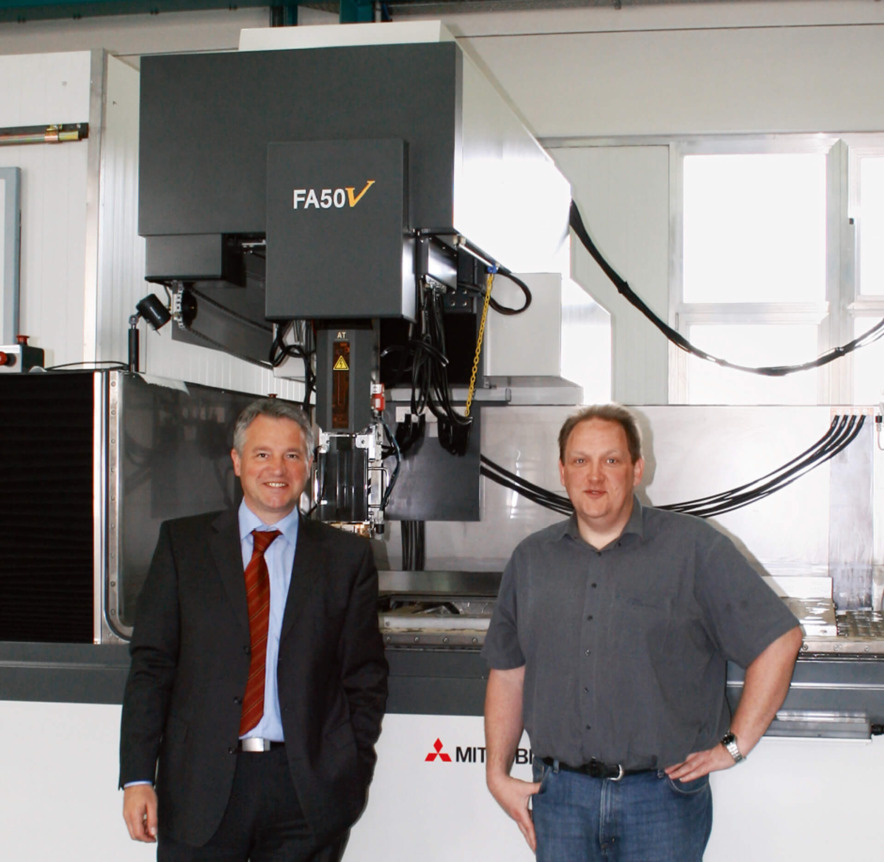 Mr Krüger (right) and Mr Neuendorf from Mitsubishi Electric (left) in front of the world’s biggest erosion machine.