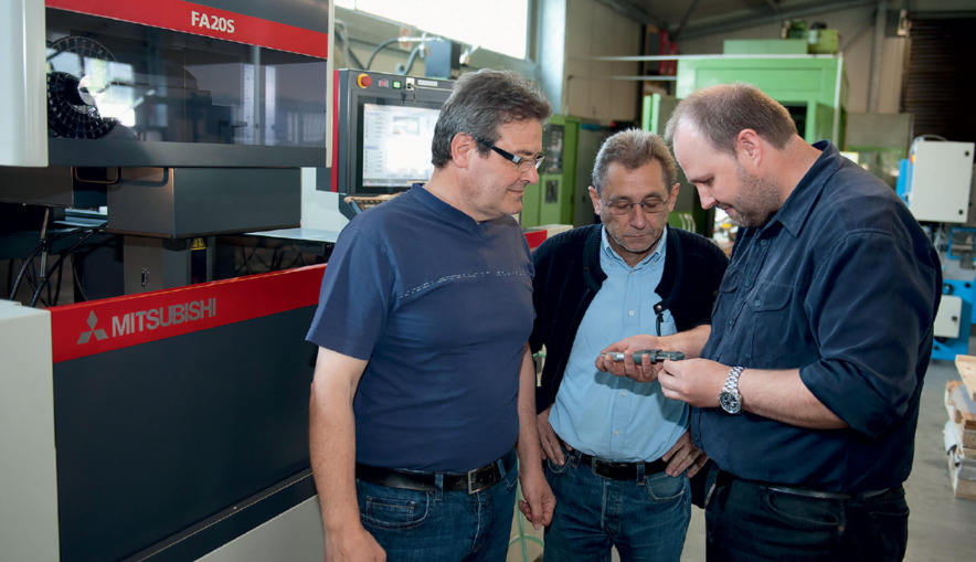 Managing partner Alfons Manzo (left) talking to design engineer Wilfried Funk (centre) and wire EDM machinist Andreas Roth.
