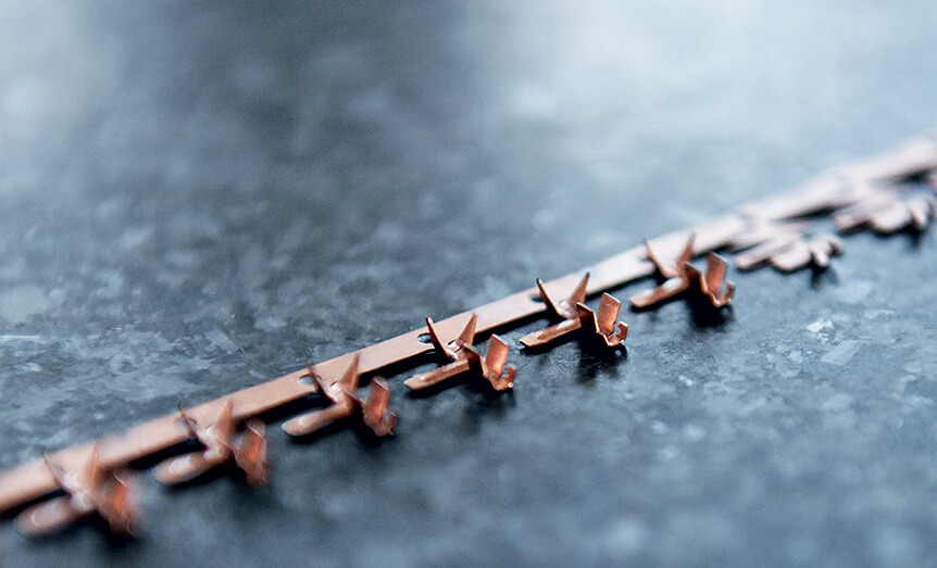 In mehreren Schritten werden aus einem Kupferband die komplex geformten Kontakte gestanzt.