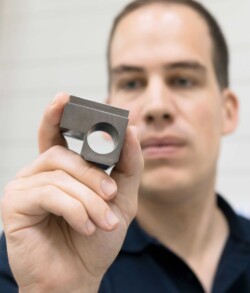 Industrial mechanic Markus Hepp checking a finished part. Wire-eroding it completely instead of drilling, milling and grinding it boosts accuracy and accelerates throughput.